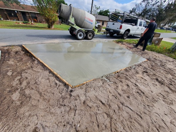 Freshly poured concrete slab with mixer on a residential street